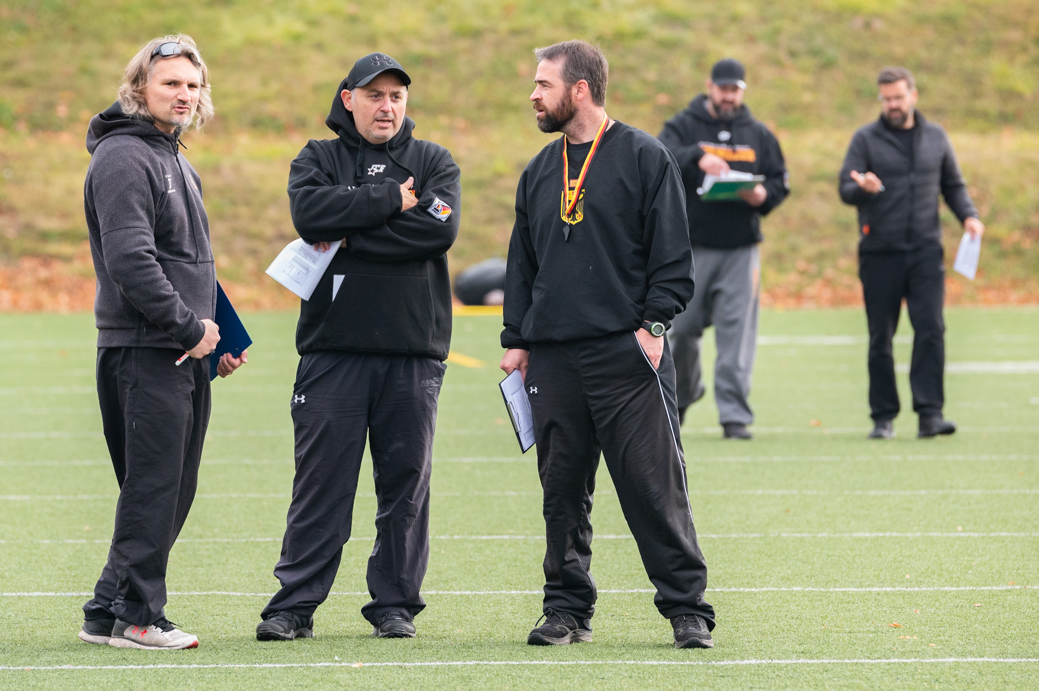 Teamchef Jordan Neuman (mit Bundesadler) diskutiert mit Coaches (Foto Manfred Löffler)